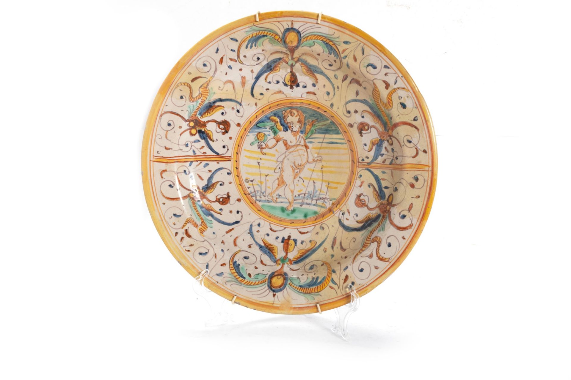 Polychrome majolica plate decorated with grotesques with putto in the centre