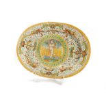 Oval dish in polychrome majolica decorated with grotesques and Cupid in the centre