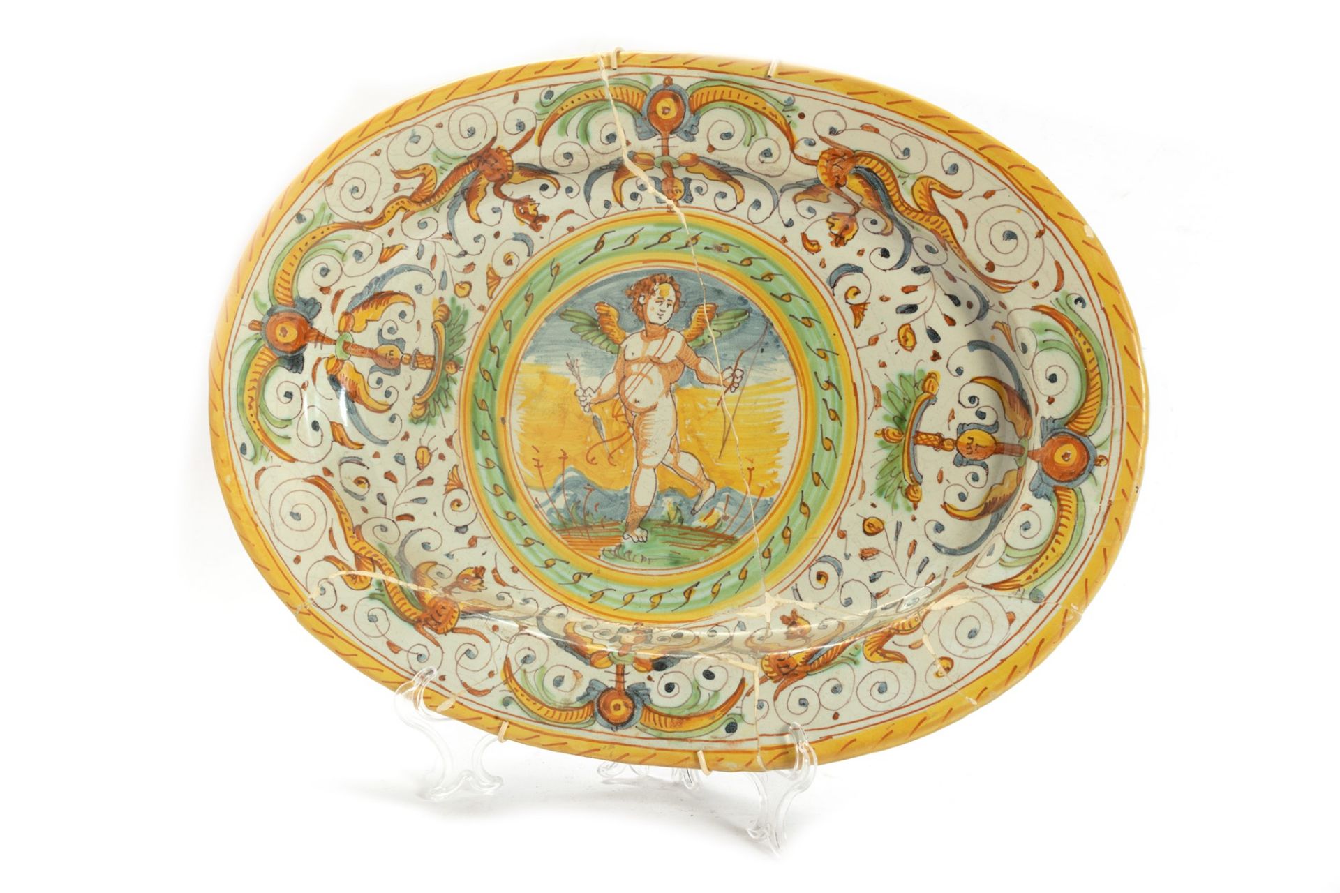 Oval dish in polychrome majolica decorated with grotesques and Cupid in the centre