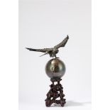 A silver sculpture of a eagle topping the world. China, 20th century