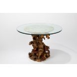 Coffee table composed of a richly carved and gilded wooden base and a round glass top