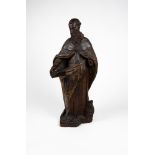 A carved wood sculpture with traces of lacquering depicting a Saint. XVIII century