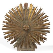 Wooden sunburst with carved and gilded central face, 19th century