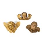 Three putto heads in lacquered and gilded wood, 18th-19th century