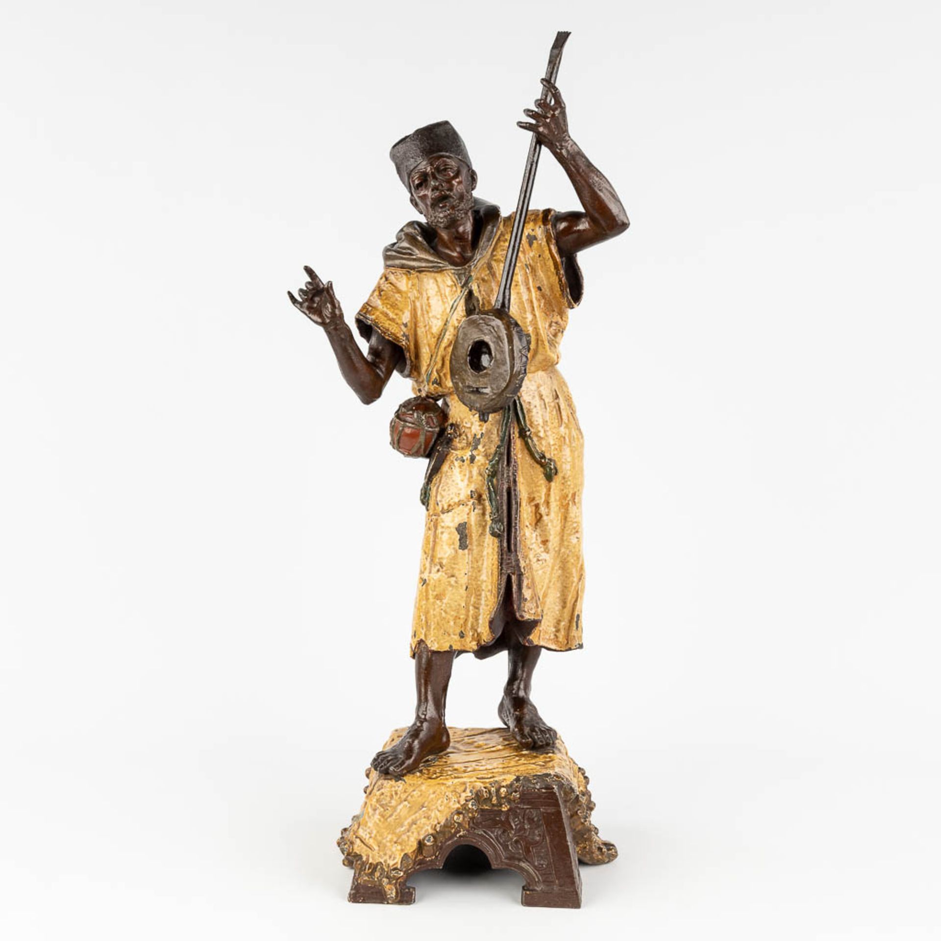 A large figurine of an Arab Bedouin, playing a musical instrument, patinated spelter. 19th C. (L:17,