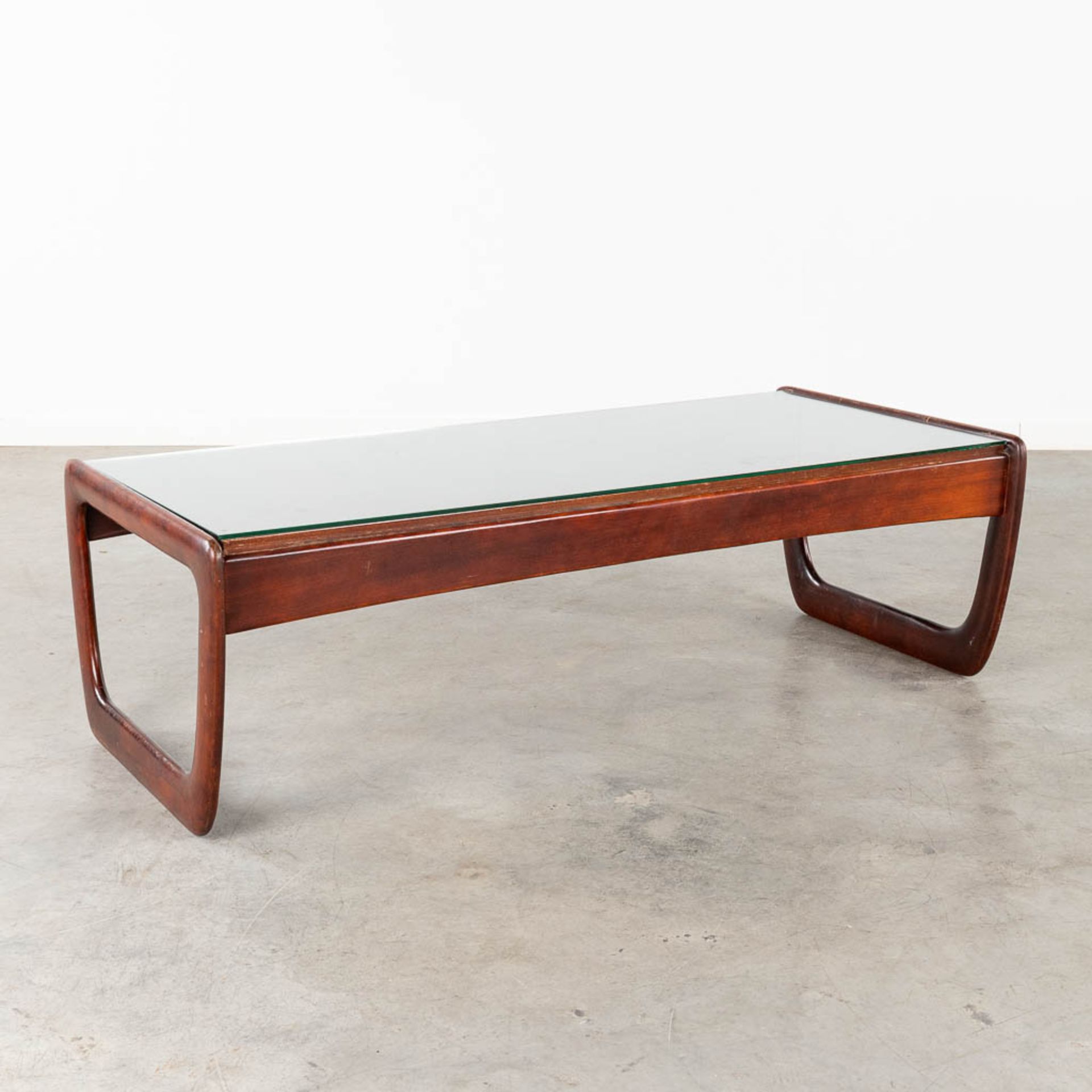 A mid-century coffee table with a glass top, probably teak. (L:30 x W:130 x H:40 cm)