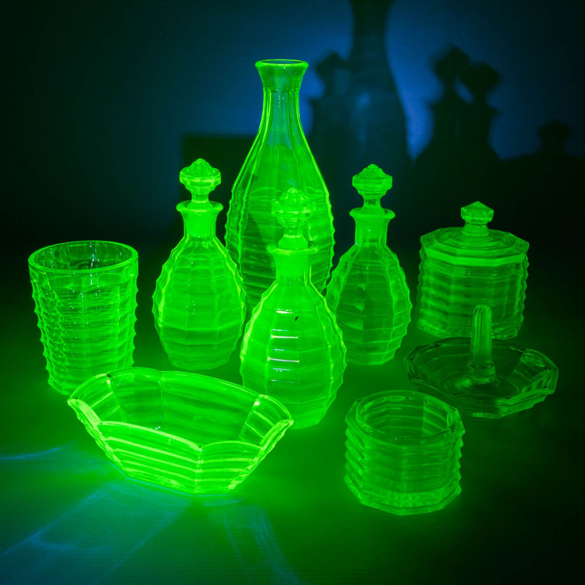 A 9-piece perfume set, made of Uranium glass. (H:21 x D:9 cm)