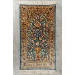 An Oriental hand-made carpet, Ghoum, Signed. (L:108 x W:60 cm)
