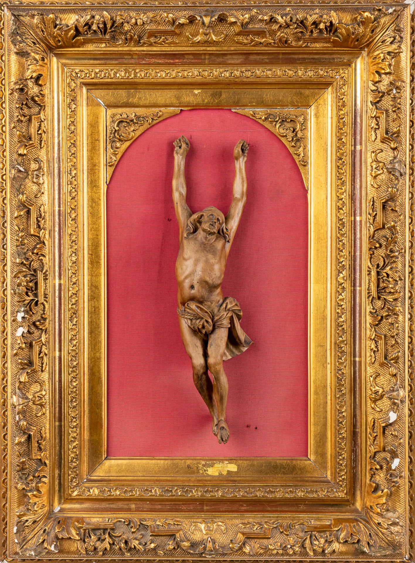 An antique wood-scultpured Corpus Christi, mounted in a gilt frame. (H:63 cm)