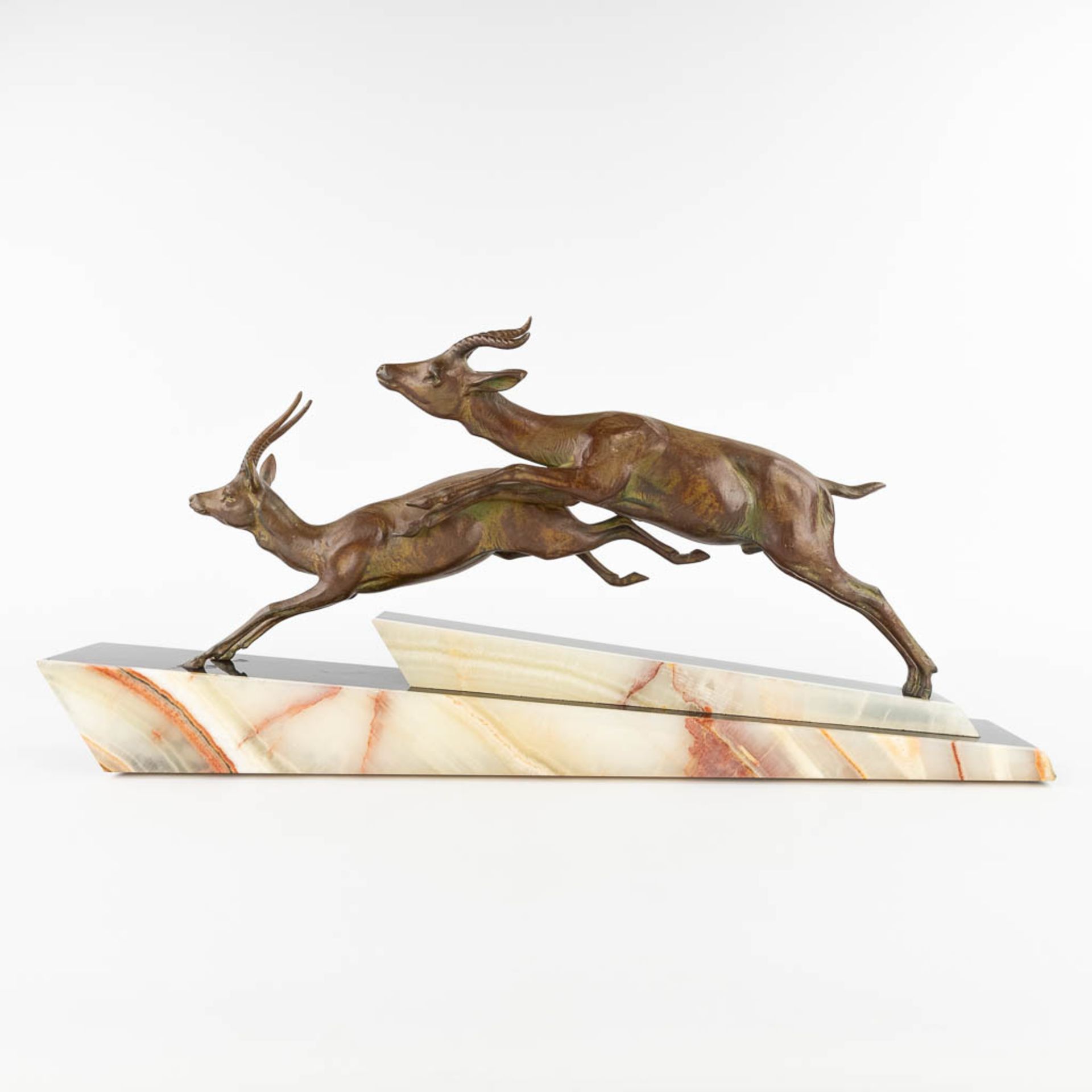 Two running deer, spelter on an onyx base, Art Deco. (L:11 x W:66 x H:31 cm)