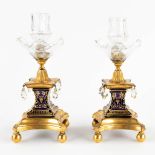 A pair of candlesticks, bronze finished with glass and porcelain. 19th C. (D:10 x W:10 x H:24 cm)