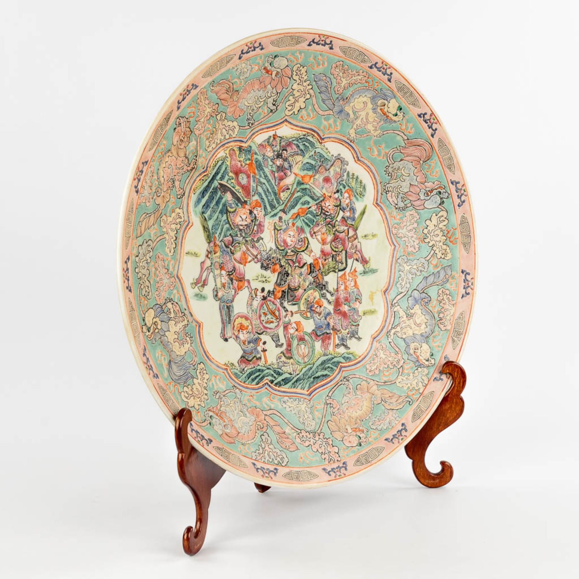 A Chinese Famille Rose plate, decorated with warriors, peaches and Foo Dogs. 19th/20th C. (D:45,5 cm - Image 3 of 13