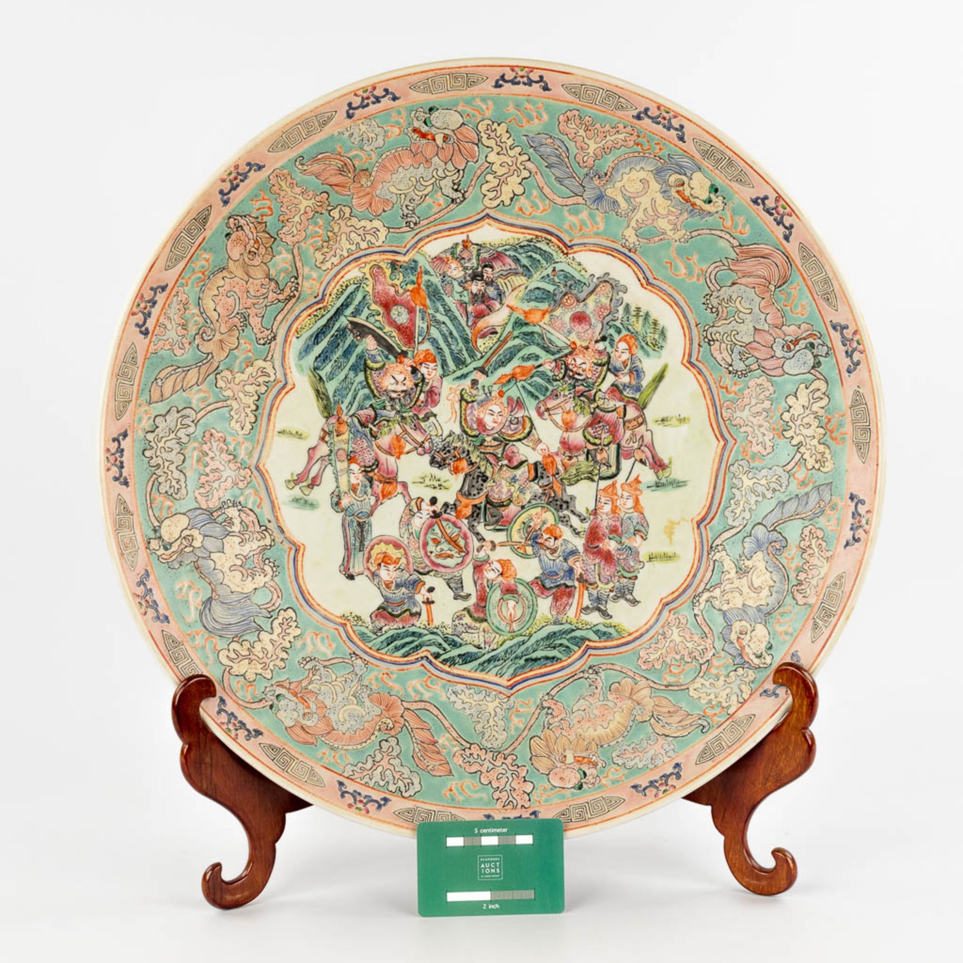 A Chinese Famille Rose plate, decorated with warriors, peaches and Foo Dogs. 19th/20th C. (D:45,5 cm - Image 2 of 13