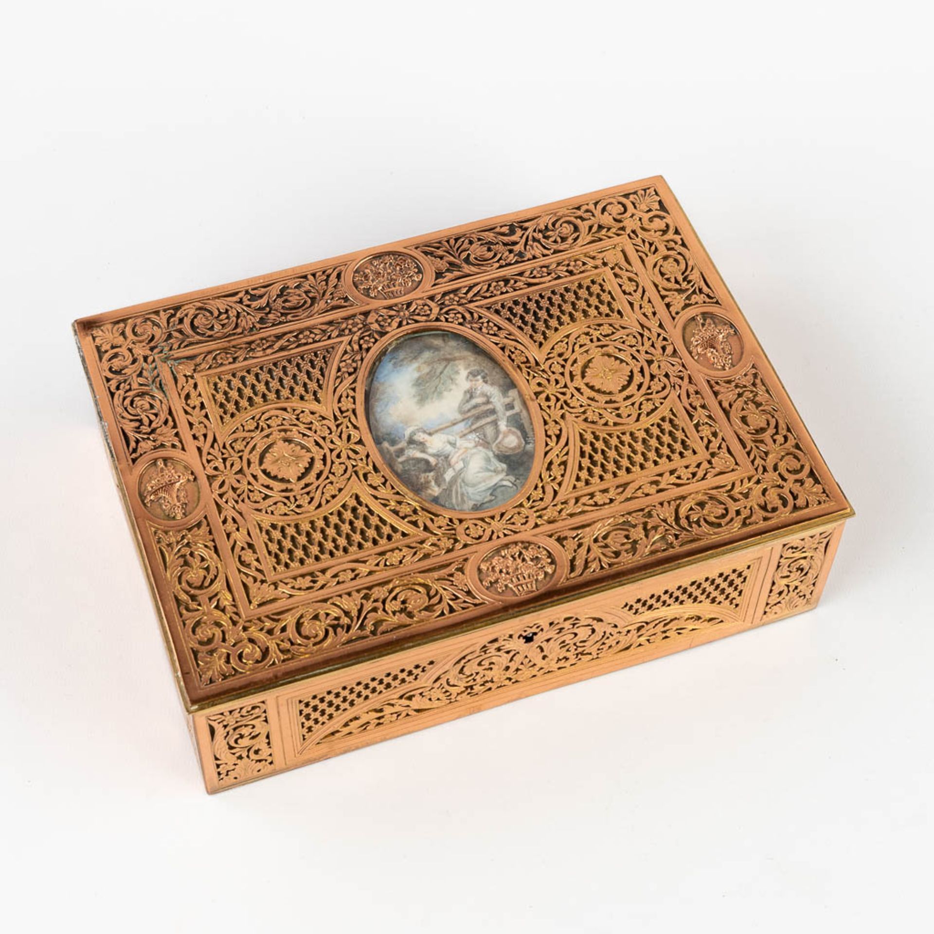 A jewellery box, ajoured brass and finished with a miniature painting. (D:16,7 x W:23 x H:6,5 cm)