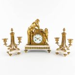 A three-piece mantle garniture clock and candelabra, gilt bronze. 19th C. (D:11,5 x W:22,5 x H:28 cm