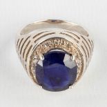 A ring with a large facetted stone, probably a sapphire, silver. Ring size: 63.