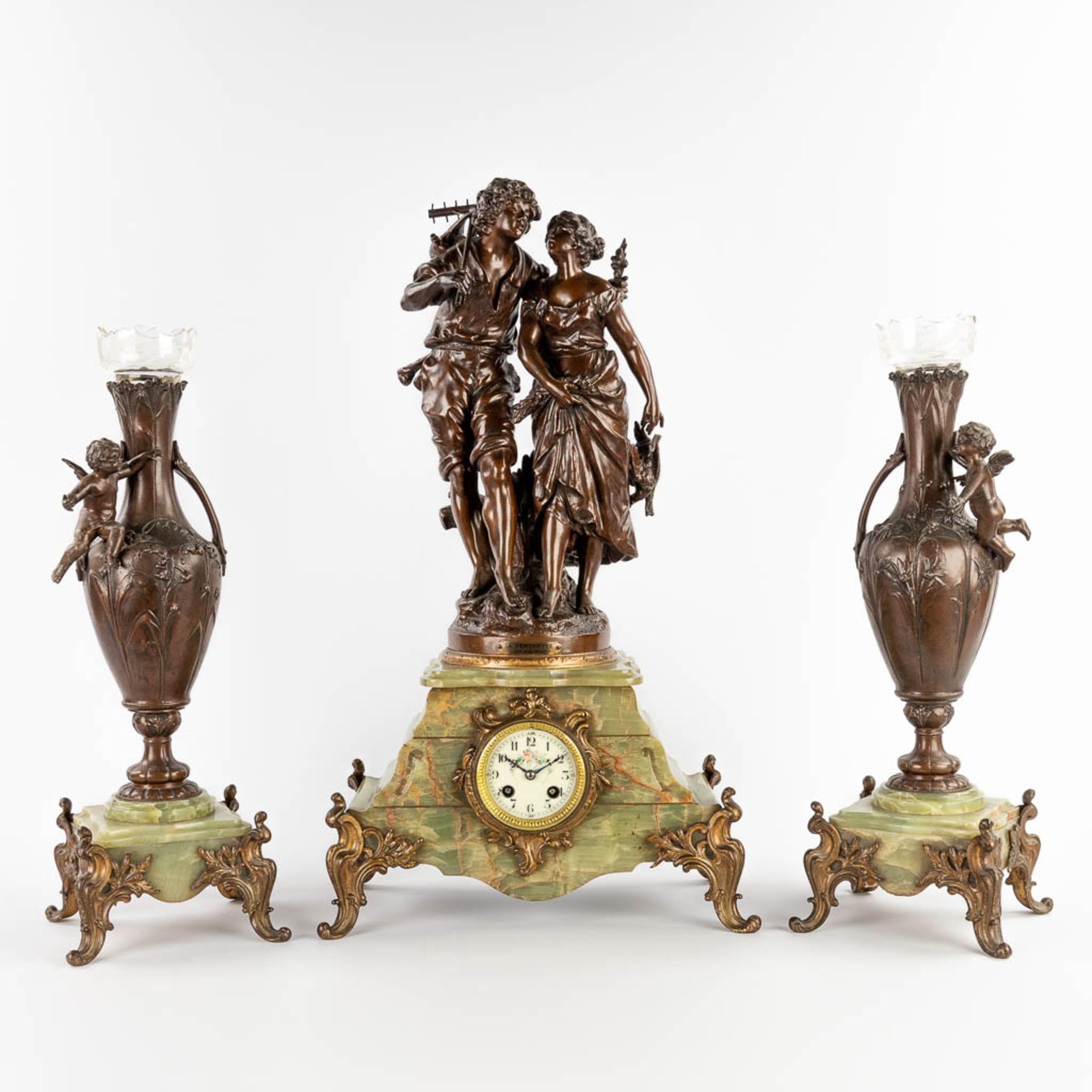 A three-piece mantle garniture clock with side pieces, spelter on an onyx base. 19th C. (D:20 x W:37