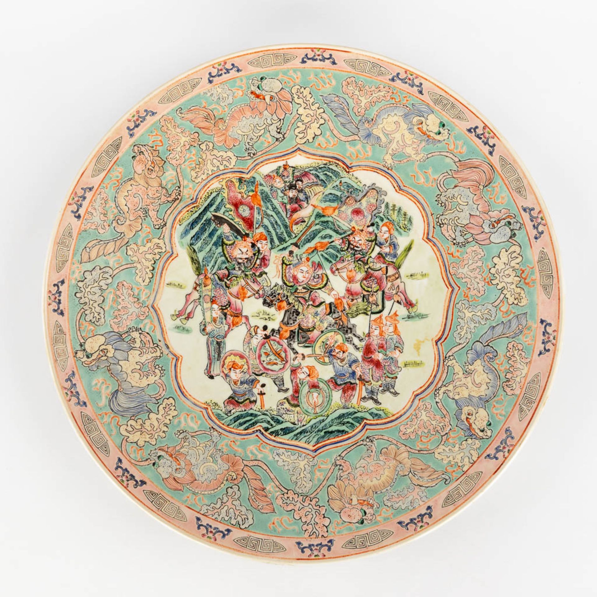A Chinese Famille Rose plate, decorated with warriors, peaches and Foo Dogs. 19th/20th C. (D:45,5 cm - Image 7 of 13