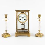 A three-piece mantle garniture clock and candlesticks. 19th C. (D:14 x W:15 x H:26 cm)