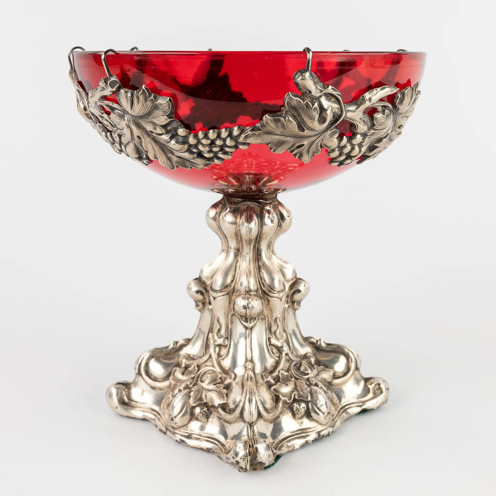 A red glass bowl on a silver base, decorated with grape vines. (H:20 x D:18,5 cm)