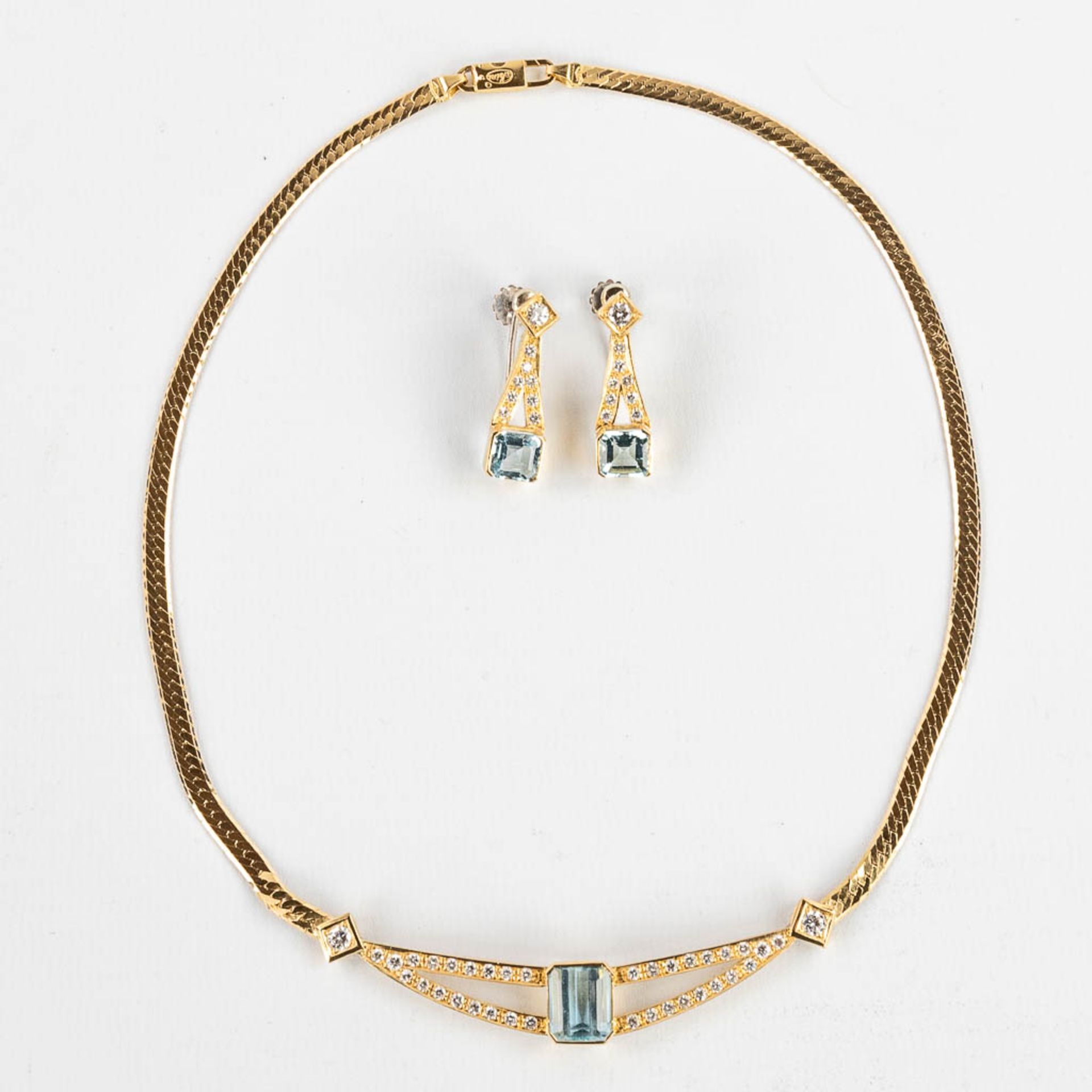 A necklace with two earrings, 18kt yellow gold Brilliants and Topaz/Aquamarine, 26,77g.