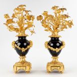 A pair of candelabra, gilt bronze on porcelain and decorated with flower decor. (D:30 x W:28 x H:53