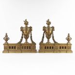 A pair of fireplace bucks, bronze in Louis XVI style and decorated with ram's heads. (D:10 x W:37 x