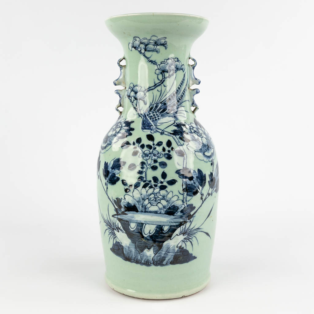 A Chinese celadon vase with blue-white decor of flora. 19th/20th C (H:42 x D:19 cm)