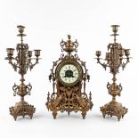 A three-piece mantle garniture clock and candelabra, patinated bronze. Circa 1900. (D:11 x W:22 x H: