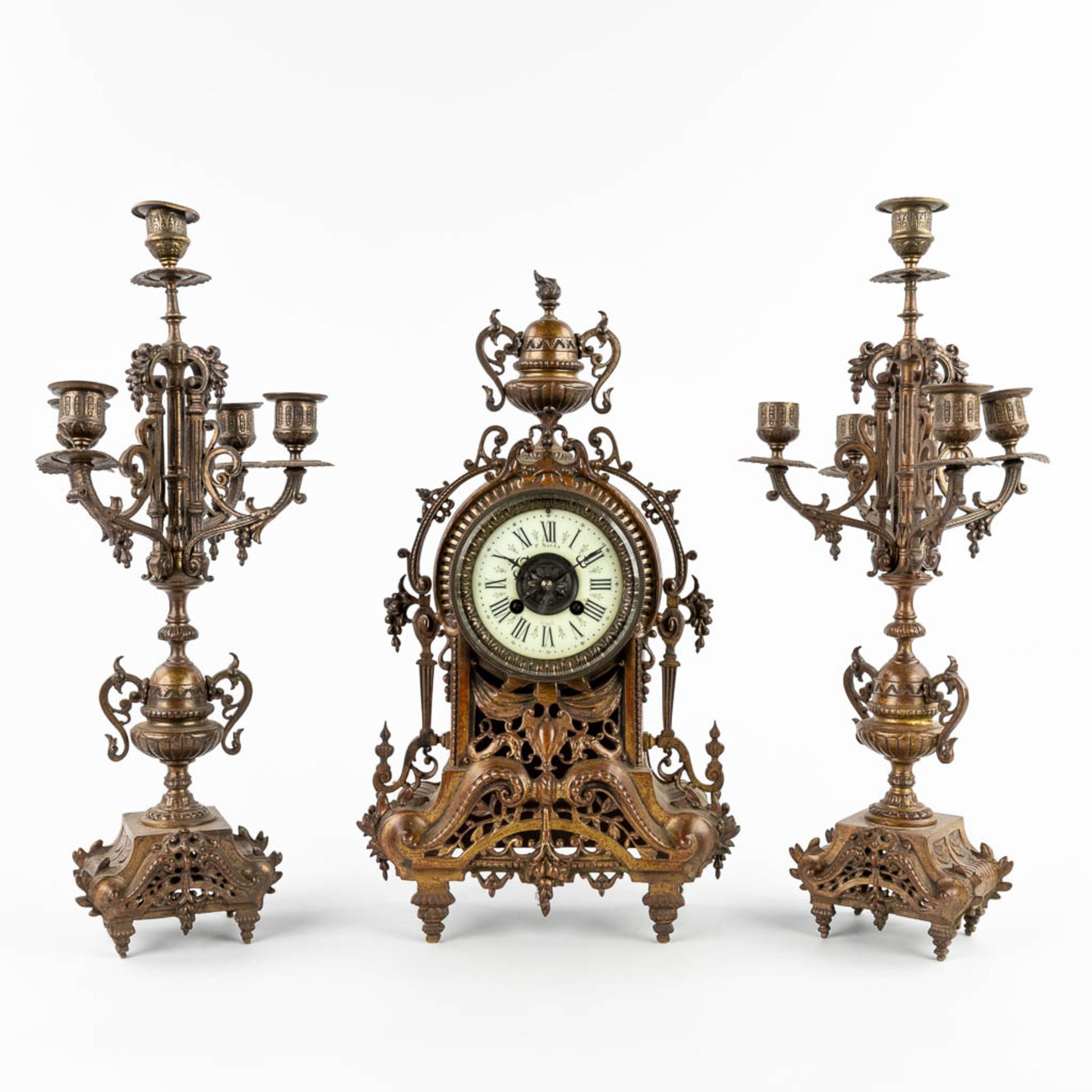 A three-piece mantle garniture clock and candelabra, patinated bronze. Circa 1900. (D:11 x W:22 x H: