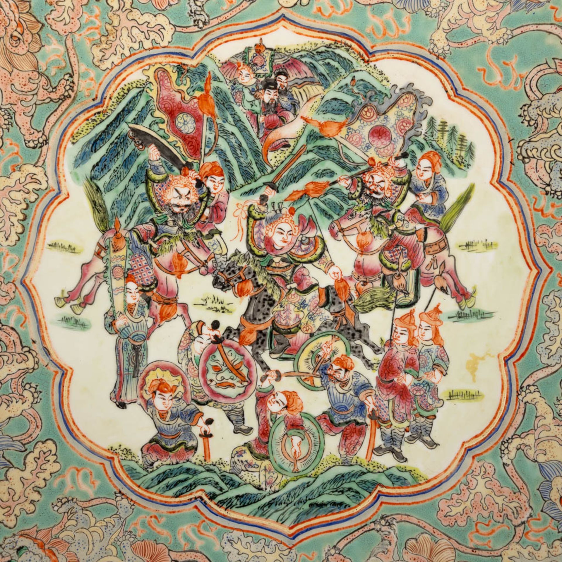 A Chinese Famille Rose plate, decorated with warriors, peaches and Foo Dogs. 19th/20th C. (D:45,5 cm - Image 8 of 13