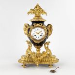 A mantle clock, gold-plated bronze on porcelain, finished with ram's heads. 19th C. (D:17 x W:46 x H