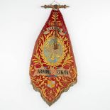 An antique banner, 'Harmonie Saint Germain, Couvin', and used in the front of a marching orchestra.