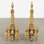 A pair of fireplace bucks, gilt bronze decorated with lion's and putti heads. 19th C. (D:16 x W:23 x