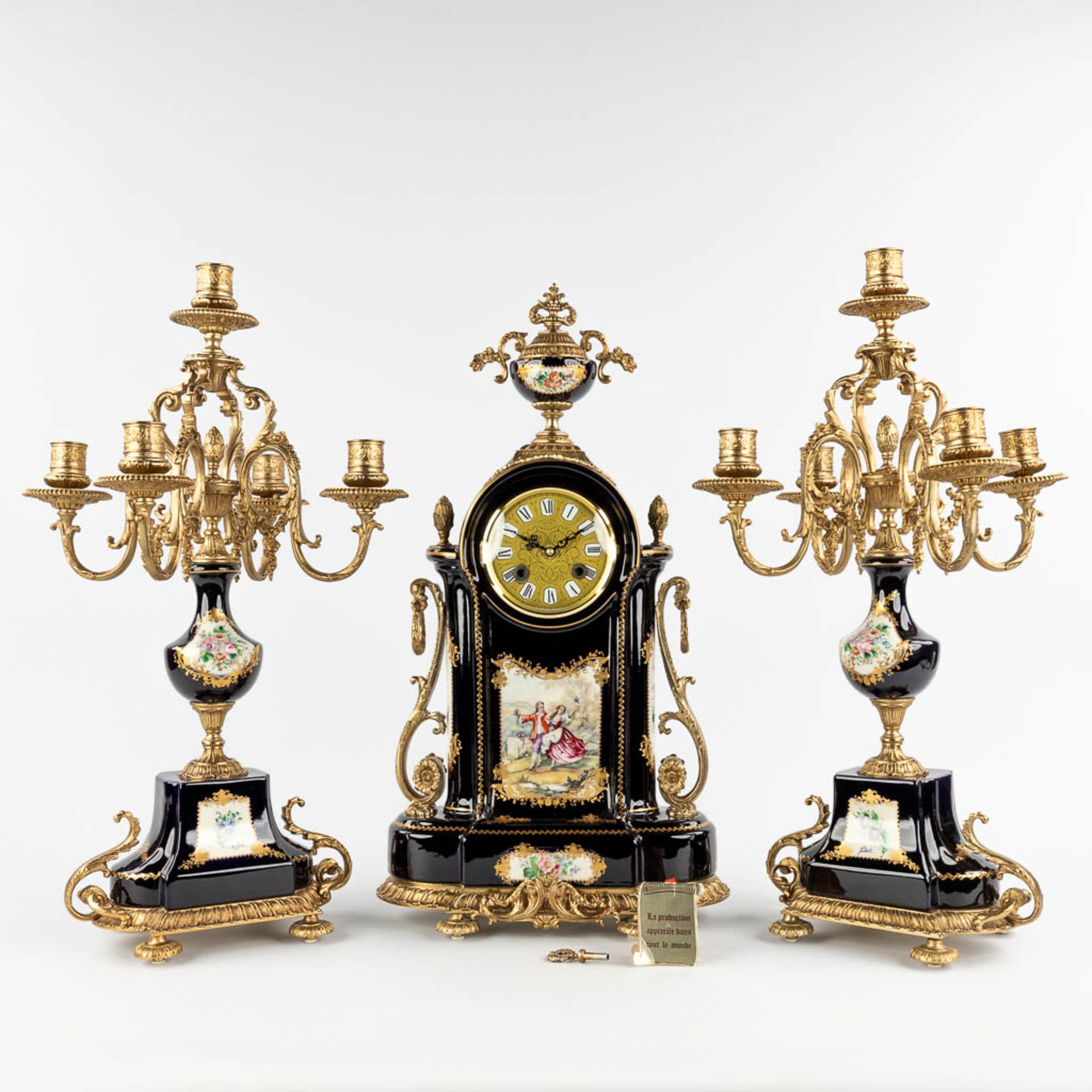 A three-piece mantle garniture clock with candelabra, porcelain mounted with bronze, marked A.C.F. d