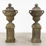 A pair of large urns with a lid, standing on a pedestal, concrete, 20th C. (D:50 x W:67 x H:173 cm)