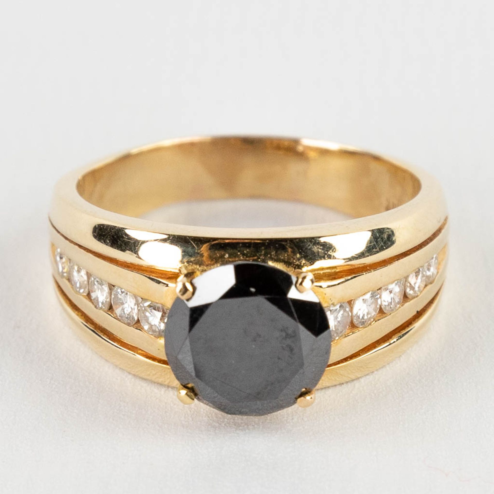 A 14 karat yellow gold ring with black diamond, appr. 2,73ct and 10 brilliant cut diamonds, appr. 0,