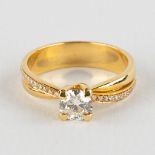 A ring, 18kt yellow gold with solitary diamond, appr. 0,61ct and smaller diamonds appr. 0,14ct. Ring