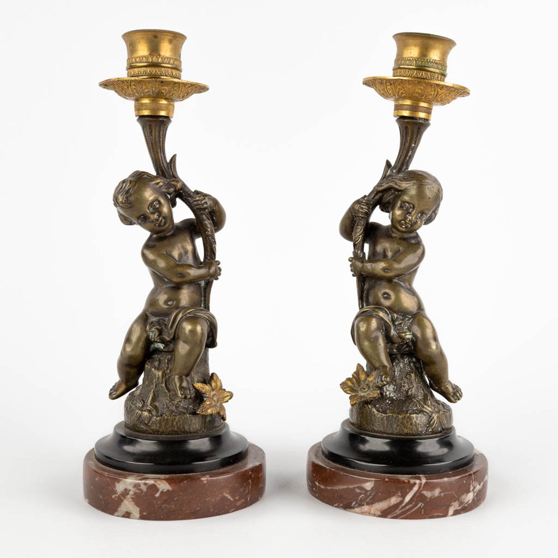 A pair of candlesticks with putti, patinated and gilt bronze. 19th C. (H:23 x D:9 cm)