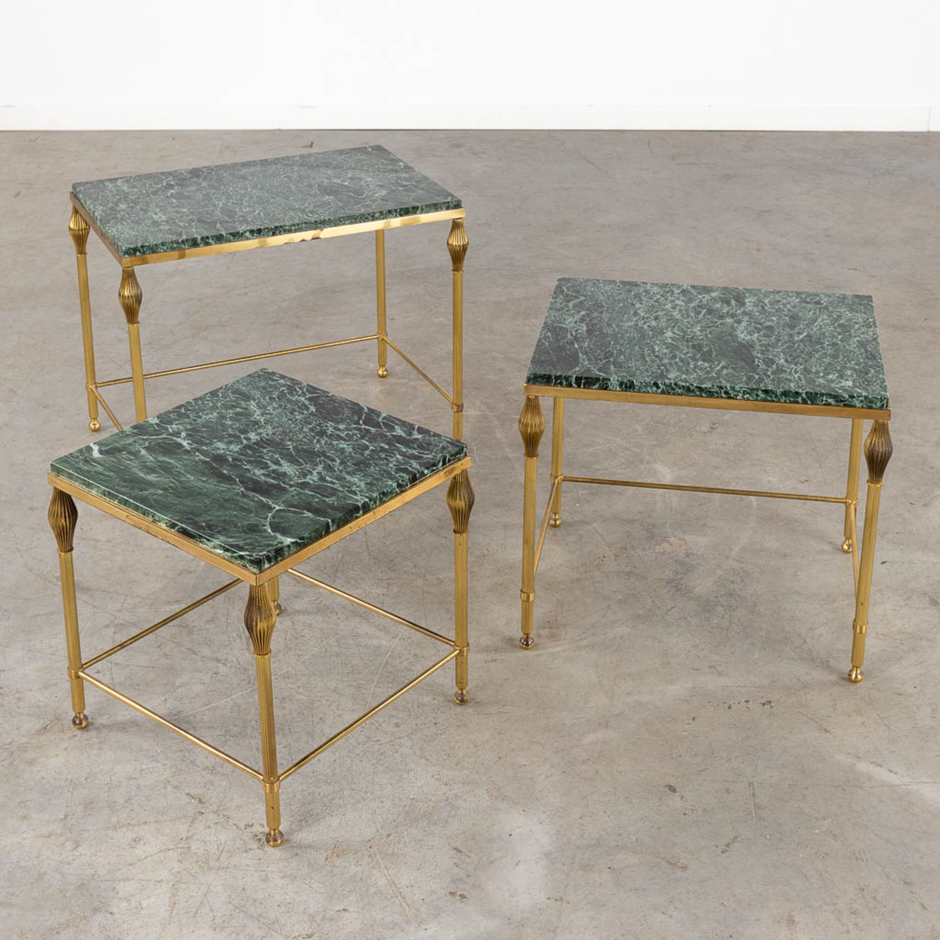 A three-piece set of nesting tables, gilt metal and a green marble. (D:37 x W:56 x H:45 cm)