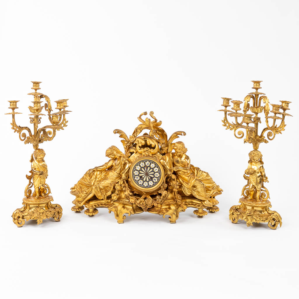 A fine three-piece mantle garniture, gilt bronze, reclined lady, man and candelabra with putti, 19th
