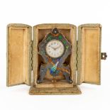 A traveller's clock, silver with hand-painted enamel. Decor of a peacock. Circa 1900. (D:2 x W:5,5 x