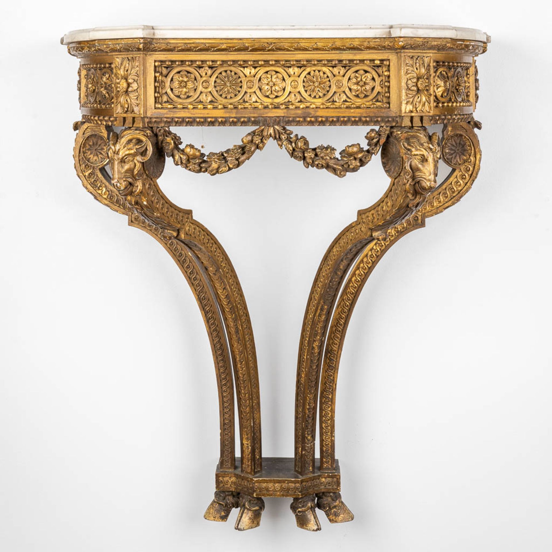 A console table with ram's heads, gilt and sculptured wood and a Carrara marble top. 19th C. (D:41 x