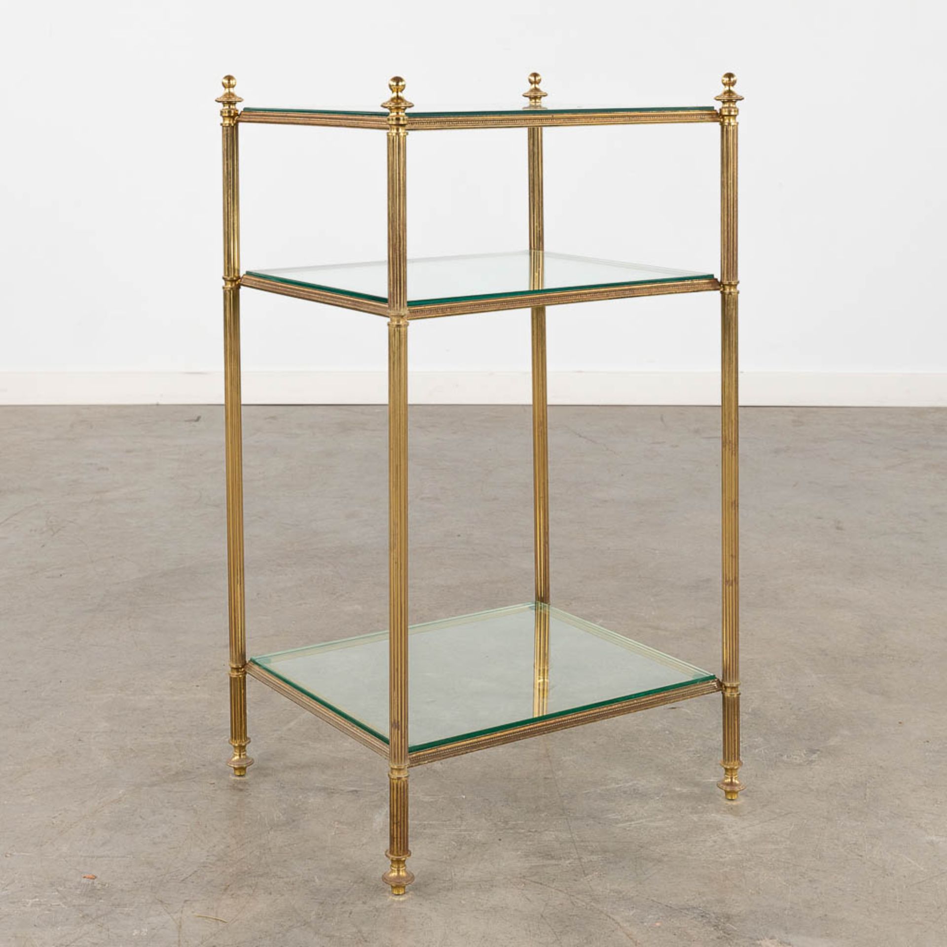 A two-tier side table, brass and glass in the style of Maison Jansen. (D:32 x W:40 x H:70 cm)