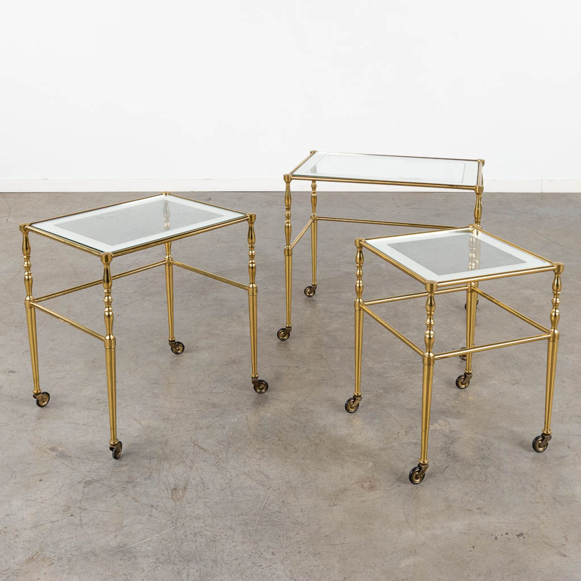 A set of nesting tables, brass and glass. 20th C. (D:39 x W:56 x H:52 cm)