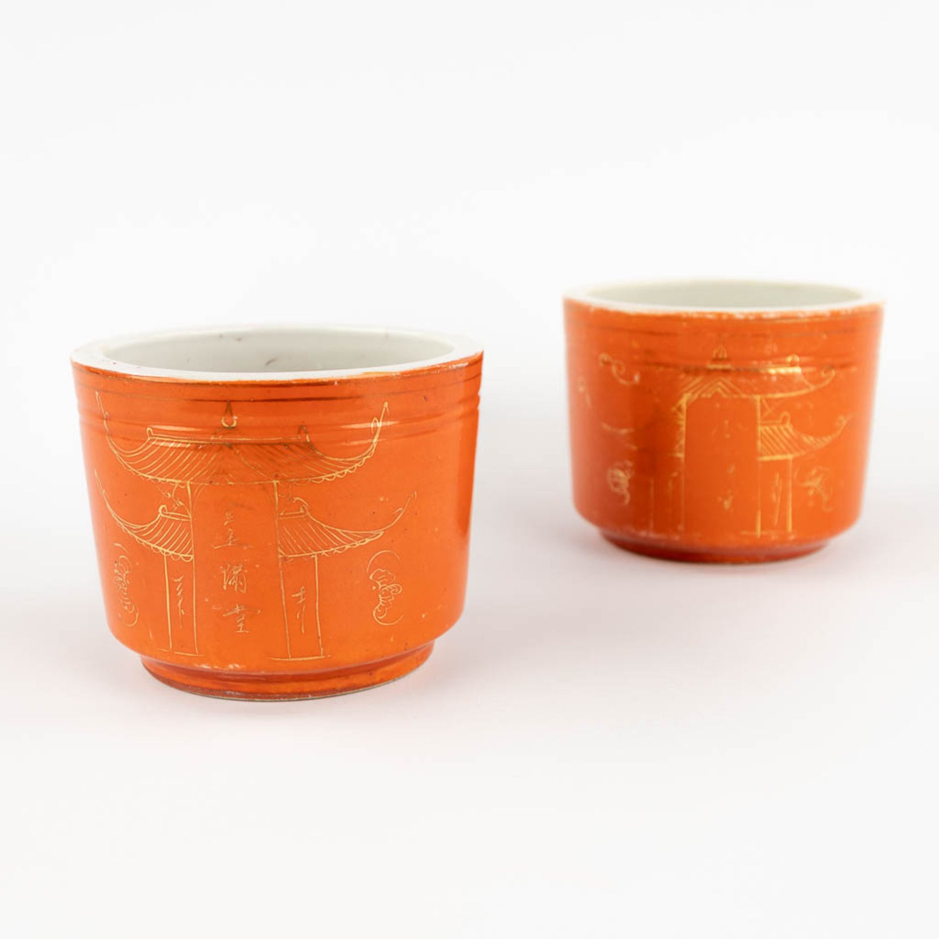 A pair of brush pots, coral red glaze with gilt decors of temples. 19th/20th C. (H:10 x D:13 cm)