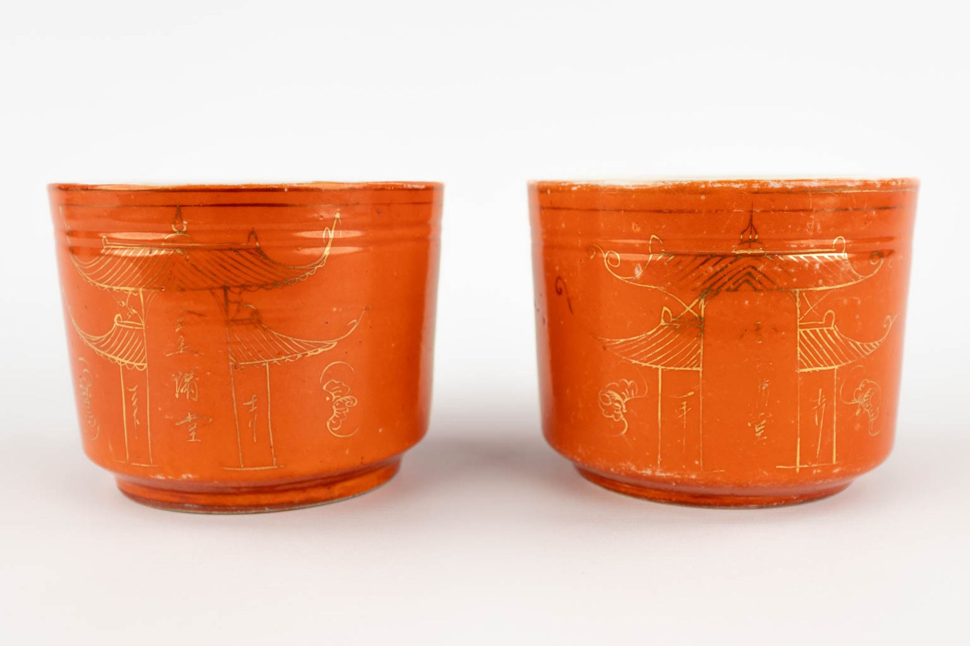 A pair of brush pots, coral red glaze with gilt decors of temples. 19th/20th C. (H:10 x D:13 cm) - Image 3 of 10