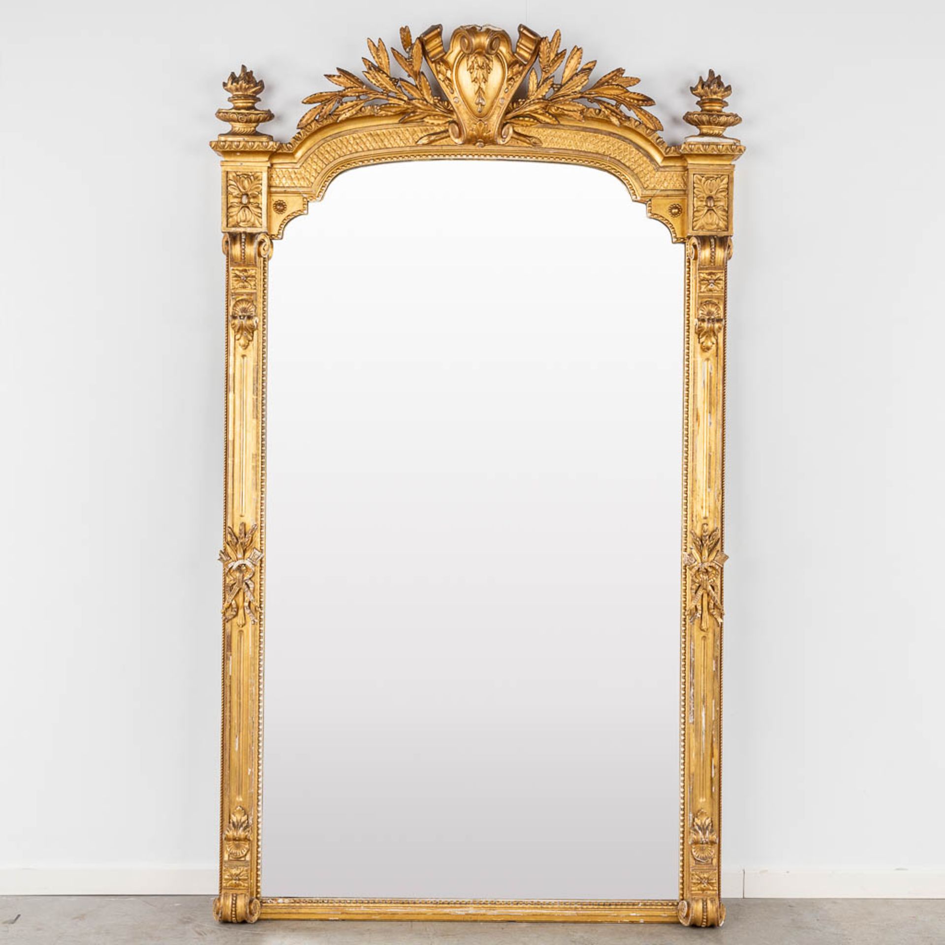 A large mirror, gilt wood and stucoo in Louis XVI style. Circa 1900. (W:123 x H:207 cm)