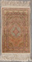 An Oriental hand-made and silk carpet, Hereke. (D:70 x W:44 cm)