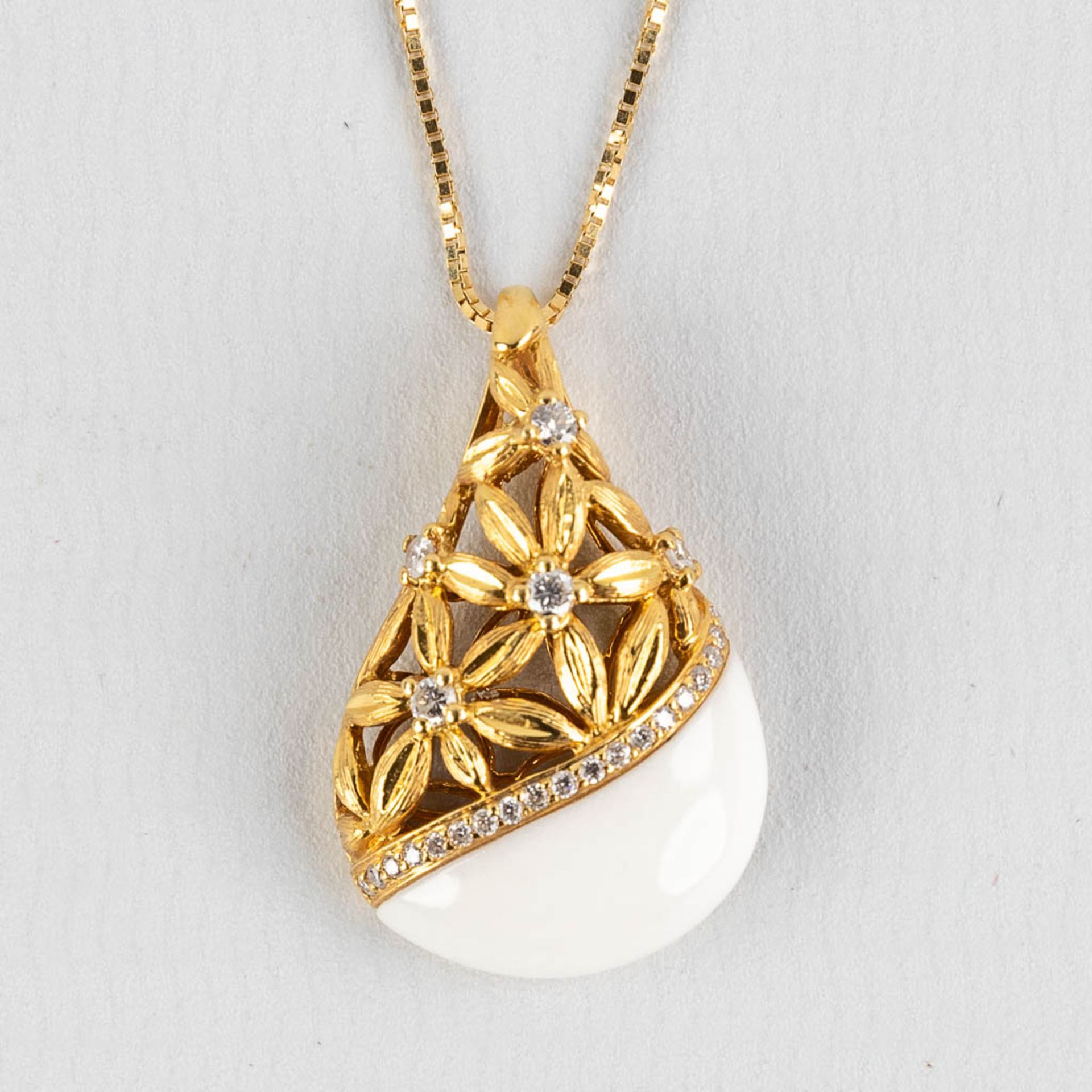 A pendant, 18kt yellow gold with brilliants, appr.,24ct, white enamel and flower decor. 6,73g.